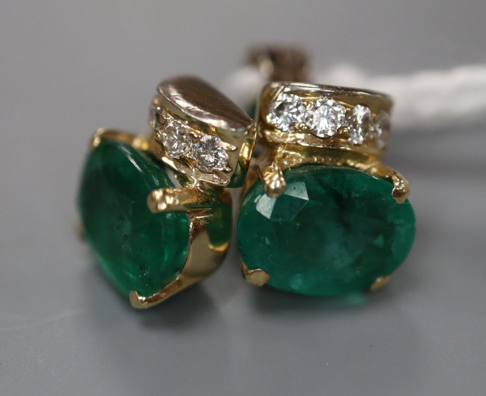 A modern pair of 750 yellow metal, oval cut emerald and four stone diamond set ear studs, 9mm, gross 2.7 grams.